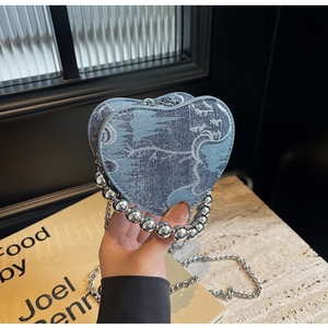 Detail of denim heart-shaped bag with landscape print and silver ball handle