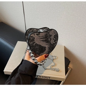Detail of heart-shaped nylon shoulder bag with silver bead handle and chain strap