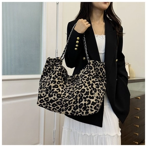 Detail view of large leopard print tote bag with stylish silver metal chain strap