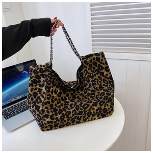 Detail of large leopard print tote bag with silver chain straps and magnetic buckle