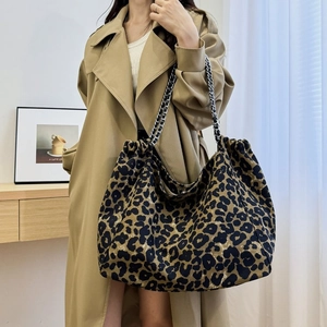 Close-up of leopard print tote bag with woven silver chain strap and drawstring detail