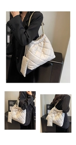 Detail of white quilted crossbody bag with gold chain strap and matching coin purse