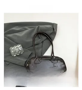 Détail de la texture en cuir verni brillant d'un sac baguette marron vintage