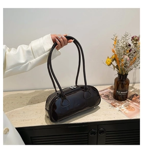 Détail du sac à bandoulière en cuir verni brillant avec double fermeture éclair et anses