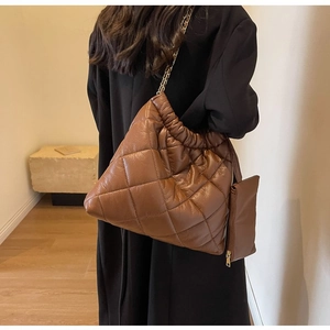 Detail of brown quilted crossbody bag with cloud pleats and chain strap