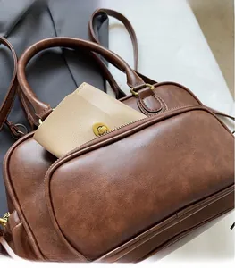 Detail of front zipper pocket on brown vintage PU handbag with beige wallet insert