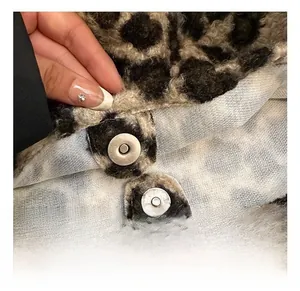 Détail des boucles magnétiques argentées sur le sac fourre-tout en nylon peluche léopard