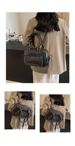 Detail of vintage black textured leather handbag with gold hardware in cafe setting