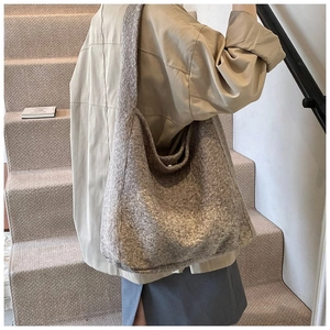 Gros plan sur la texture pelucheuse d'un grand sac hobo taupe en fausse fourrure