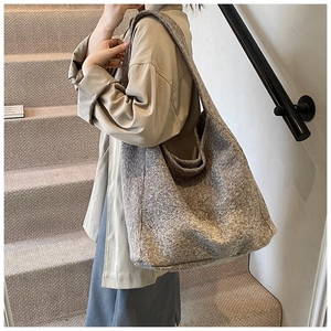 Détail du sac cabas en tissu gris montrant la texture du matériau et le design épuré