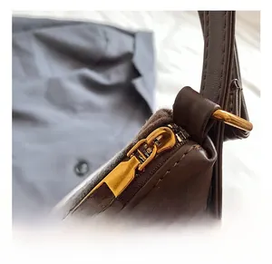 Close-up of premium gold metal zipper hardware on dark brown quilted leather bag