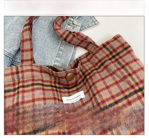 Close-up of red and yellow plaid woolen bag with signature YOU&JOLLYHOUSE woven label