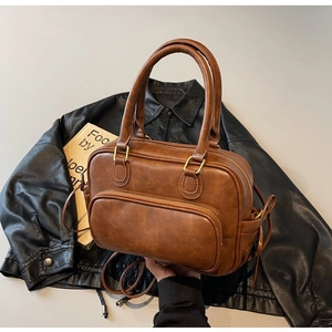 Detail of vintage brown PU leather Boston bag with textured finish and brass zippers