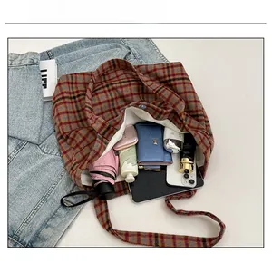 Macro view of plaid canvas tote bag interior showing ample storage for daily essentials