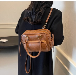 Detail of vintage brown PU leather crossbody bag with multiple functional zip pockets