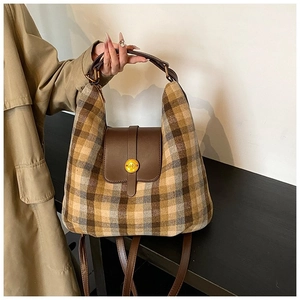 Detail of hobo bag with brown checkered fabric, leather trim, and golden round buckle