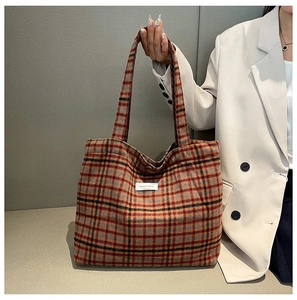 Detail of tweed plaid tote bag with romantic house label and round button closure