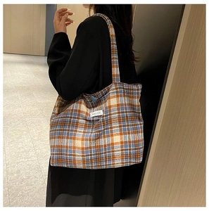Detail of checkered tote bag with blue heart charm and decorative white label
