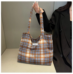 Detail of blue and orange plaid tote bag with stitching and fabric texture