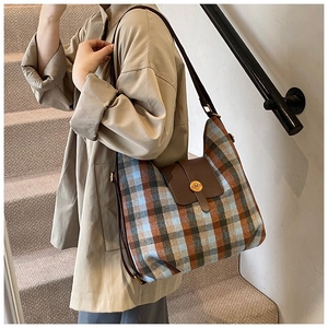 Detail of tweed quilted pattern bag with brown leather flap and golden N-logo buckle