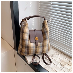 Detail of vintage plaid multi-functional bag with leather flap and gold metal buckle