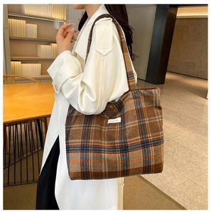 Detail of vintage plaid tote bag in dark brown and orange with woven fabric texture