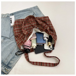 Flat lay of a spacious plaid tote bag showcasing everyday essentials and large capacity