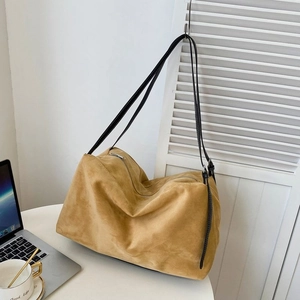 Detail of camel suede tote bag showing large capacity and black leather shoulder straps