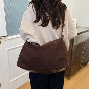 Brown faux suede hobo tote bag for women with adjustable strap in casual interior setting