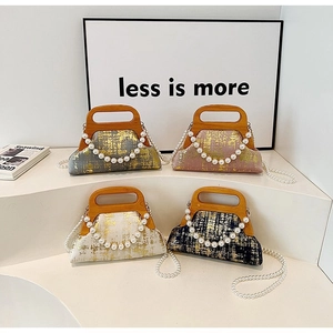Détail de quatre sacs à main rétro à paillettes dorées, poignées en bois et perles