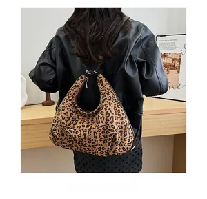Detailed back view of a stylish leopard print hobo bag worn in a cozy home interior