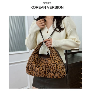 Detail of leopard print hobo bag with animal pattern texture and slim shoulder strap