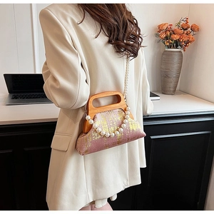 Sac vintage rose avec texture dorée, poignée en bois et détails de perles élégants