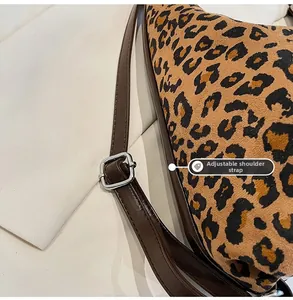 Detail of leopard print faux fur bag showing the adjustable brown leather strap and buckle