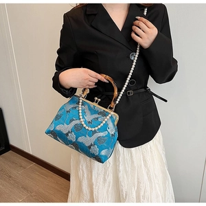Detail of blue brocade handbag with bamboo handle, crane embroidery and pearl strap