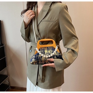 Détail du sac à bandoulière rétro avec poignée en bois, perles et texture brocart bleu