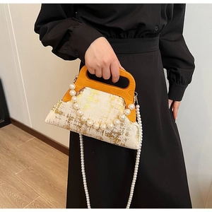 Détail du sac de soirée vintage avec poignée en bois orange et bandoulière en perles