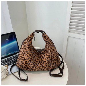 Detail of leopard print handbag with leather strap and silver hardware on white table