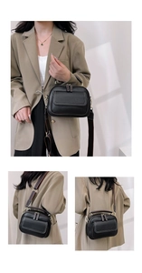 Detail der schwarzen Kiesellederhandtasche mit gestreiftem Gurt und goldener Hardware