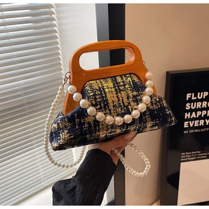Détail du sac vintage bleu marine avec poignée en bois et bandoulière en perles