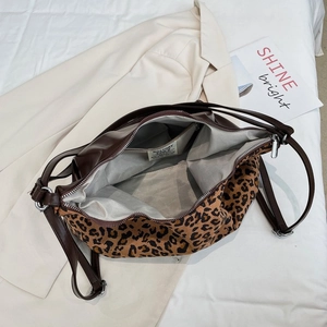 Interior detail of leopard print tote featuring grey herringbone lining and zipper pocket