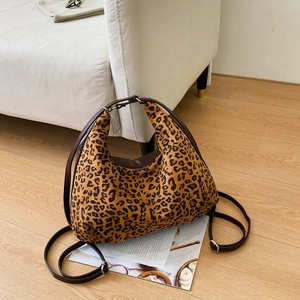 Close-up of leopard print shoulder bag with brown leather strap and silver metal hardware