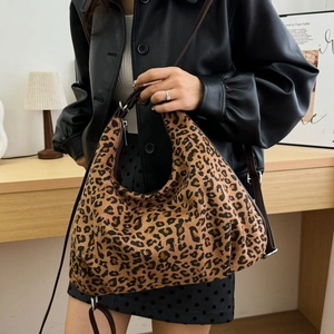 Detail shot of leopard print shoulder bag with brown leather strap and silver zipper