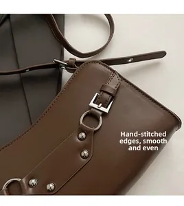 Detail of dark brown leather bag with silver metal buckle and handmade stitching craft