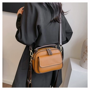 Braune Lederhandtasche mit Doppelreißverschluss und verstellbarem Riemen am Model gezeigt