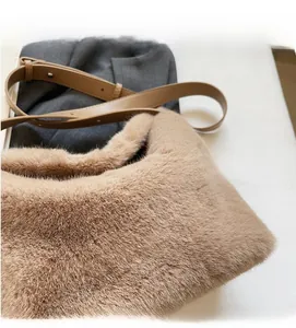 Close-up of khaki plush shoulder bag featuring soft faux fur and brown leather strap