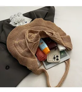 Detail view of woven shoulder bag showing spacious interior with tablet and umbrella