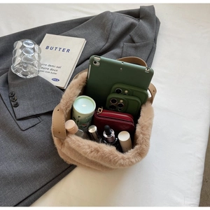 Spacious interior of khaki plush handbag showing storage capacity for iPad and skincare