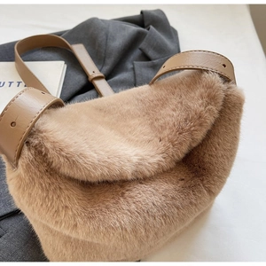 Close-up of fluffy faux fur shoulder bag with premium leather strap and metal buckle