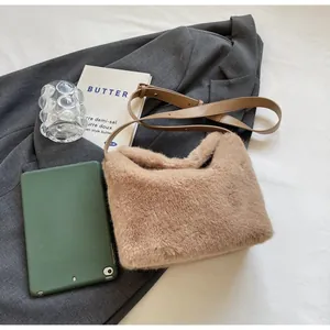 Detail of caramel faux fur shoulder bag with leather strap on a grey suit jacket